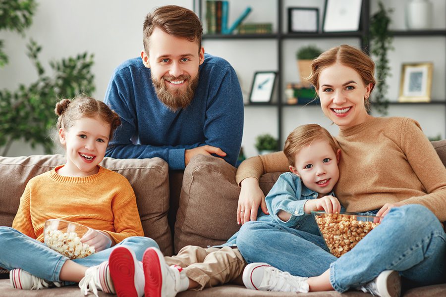 Personal Insurance - Joyful Family Resting on Sofa Together